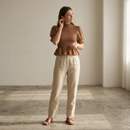 Natural lifestyle image of a model wearing apricot-lantern-sleeve-shirred-plaid-tee