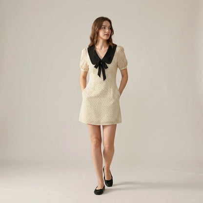 Natural lifestyle image of a model wearing apricot-polka-dot-contrasting-mini-dress