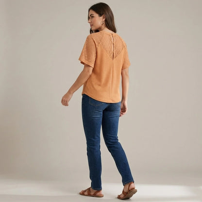 Second natural lifestyle image of a model wearing apricot-v-neck-cut-out-knit-tee