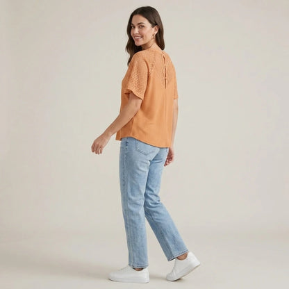 Third natural lifestyle image of a model wearing apricot-v-neck-cut-out-knit-tee