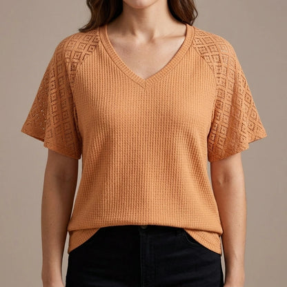 Model wearing apricot-v-neck-cut-out-knit-tee with close focus on the product