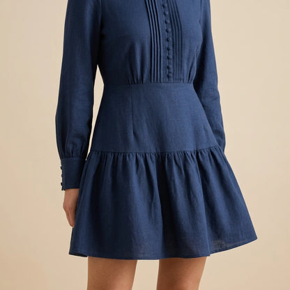 Model wearing blue-a-line-pleated-mini-dress with close focus on the product