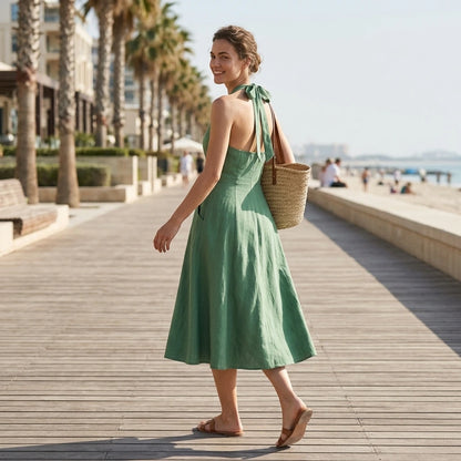 Second natural lifestyle image of a model wearing green-halter-button-pockets-midi-dress