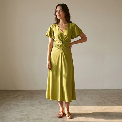 Natural lifestyle image of a model wearing green-v-neck-ruffle-sleeve-midi-dress