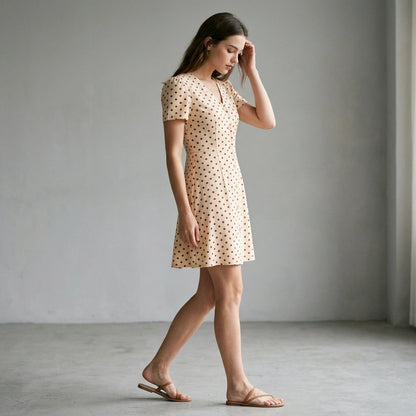 Second natural lifestyle image of a model wearing the-beige-polka-dot-button-mini-dress
