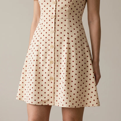 Model wearing the-beige-polka-dot-button-mini-dress with close focus on the product